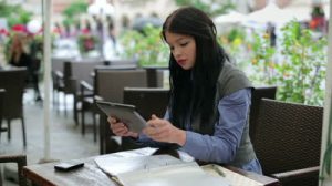 stock-footage-businesswoman-working-with-tablet-computer-and-documents-in-cafe