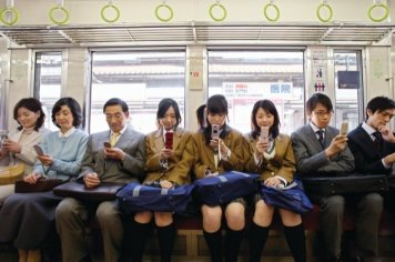 Commuters Using Cell Phones on Train --- Image by © Tokyo Space Club/Corbis